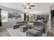 Open-concept living room with gray sofa, connecting to the kitchen and dining area at 100 Arrowtown Way, Kenly, NC 27542