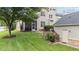 A serene backyard featuring lush green grass, mature trees, and a well-maintained exterior of the home at 100 Tobacco Leaf Ln, Apex, NC 27502