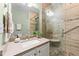 Bathroom featuring a glass door shower, pebble floor, and tiled walls at 100 Tobacco Leaf Ln, Apex, NC 27502