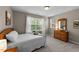 Bedroom featuring a wooden dresser, white bedding, and large windows at 100 Tobacco Leaf Ln, Apex, NC 27502
