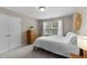 Bedroom with a wooden dresser, white bedding, and natural light from the window at 100 Tobacco Leaf Ln, Apex, NC 27502