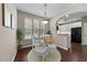 Bright dining area with a round table, white chairs, a pendant light, and an open view of the kitchen at 100 Tobacco Leaf Ln, Apex, NC 27502