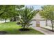 Beautiful landscaped front yard with mature trees, a well-maintained lawn, and an attached two-car garage at 100 Tobacco Leaf Ln, Apex, NC 27502