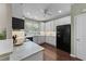 Modern kitchen with white cabinets, black appliances, a window above the sink, and hardwood floors at 100 Tobacco Leaf Ln, Apex, NC 27502