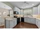 Bright kitchen featuring white cabinetry, black appliances, and a view of the dining area through an archway at 100 Tobacco Leaf Ln, Apex, NC 27502