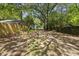 View of the spacious backyard with a grassy area, mature trees and houses in the background at 1022 Dorothea Dr, Raleigh, NC 27603