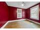 Empty bedroom with hardwood floors, two windows with blinds, and red walls at 1022 Dorothea Dr, Raleigh, NC 27603