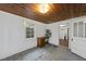 Versatile living space with wood ceiling, a desk, concrete floors, and an open doorway, adaptable for various needs at 1022 Dorothea Dr, Raleigh, NC 27603