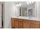 Bathroom with wood cabinets, double sinks, large mirror, and white walls at 103 Ransomwood Dr, Apex, NC 27539