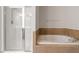 Bright bathroom featuring a glass enclosed shower and luxurious soaking tub at 103 Ransomwood Dr, Apex, NC 27539