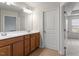 Bathroom with wooden cabinets, double sinks, and a large mirror and door at 103 Ransomwood Dr, Apex, NC 27539
