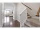 Inviting hallway featuring hardwood floors, a staircase with carpet runner, and access to the living room at 103 Ransomwood Dr, Apex, NC 27539