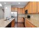 Kitchen featuring granite countertops, stainless steel appliances, wood cabinets, and a central island at 103 Ransomwood Dr, Apex, NC 27539