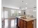 Kitchen with granite countertops and a central island flowing to the living area filled with natural light at 103 Ransomwood Dr, Apex, NC 27539