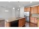 Kitchen with stainless steel appliances, wood cabinets, and a granite island with a sink and dishwasher at 103 Ransomwood Dr, Apex, NC 27539