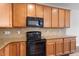 Kitchen with wood cabinets, granite countertops, stainless steel refrigerator, and black oven at 103 Ransomwood Dr, Apex, NC 27539