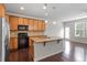 Kitchen with granite countertops, stainless steel appliances, wood cabinets, and an island with a sink at 103 Ransomwood Dr, Apex, NC 27539