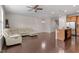 Open-concept living room featuring hardwood floors, a leather sofa, and an adjacent kitchen at 103 Ransomwood Dr, Apex, NC 27539