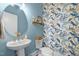 Charming powder room with blue walls, modern fixtures, and unique floral wallpaper at 10310 Sablewood Dr # 211, Raleigh, NC 27617