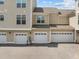Exterior view of townhome garages with white doors and tan siding at 10310 Sablewood Dr # 211, Raleigh, NC 27617