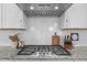 Close-up of kitchen with stainless-steel range, white cabinets, and mosaic tile backsplash at 10310 Sablewood Dr # 211, Raleigh, NC 27617
