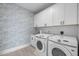 Well-organized laundry room with modern machines, sink and ample white cabinet storage at 10310 Sablewood Dr # 211, Raleigh, NC 27617