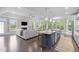 Open-concept living room flows into kitchen, boasting hardwood floors, fireplace, and abundant natural light at 10310 Sablewood Dr # 211, Raleigh, NC 27617