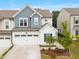 Charming two-story home with a white garage door and blue accent siding and well manicured front yard at 1038 Felman Rd, Durham, NC 27703