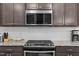 A kitchen featuring modern stainless steel appliances and brown cabinets with white backsplash at 1038 Felman Rd, Durham, NC 27703