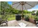 Cozy outdoor patio with umbrella, grill, and landscaped backyard offers perfect relaxation and entertaining space at 1038 Felman Rd, Durham, NC 27703