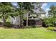 A well-manicured backyard with a lawn, mature trees, covered porch, and patio at 105 Acorn Ridge Ln, Holly Springs, NC 27540