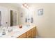 Well-lit bathroom with double sinks, a large mirror, and neutral decor at 105 Acorn Ridge Ln, Holly Springs, NC 27540