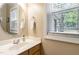 Bright bathroom featuring a modern sink, large mirror, and window with natural light at 105 Acorn Ridge Ln, Holly Springs, NC 27540