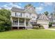 Charming two-story home with a front porch, attached two-car garage, and a well-manicured lawn at 105 Acorn Ridge Ln, Holly Springs, NC 27540