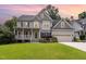 Charming two-story home featuring a spacious front yard, beautiful landscaping, and a two-car garage at 105 Acorn Ridge Ln, Holly Springs, NC 27540