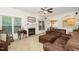 Spacious living room with a fireplace, large windows, and comfortable brown sectional at 105 Acorn Ridge Ln, Holly Springs, NC 27540