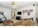 Spacious living room with neutral carpet, flat screen TV, ceiling fan and exercise equipment at 105 Acorn Ridge Ln, Holly Springs, NC 27540
