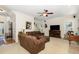 Inviting living room with a comfortable brown sectional, ceiling fan, and neutral carpet at 105 Acorn Ridge Ln, Holly Springs, NC 27540