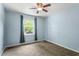 Bright bedroom with neutral carpet, a ceiling fan, and view of a tree-lined street at 105 Otter Dr, Cary, NC 27513