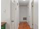 Hallway with hardwood floors, white walls, and access to multiple rooms and storage at 105 Otter Dr, Cary, NC 27513