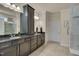 Bathroom showcasing dark vanity, dual sinks, large mirror, and modern finishes at 1120 Hooper Pl, Durham, NC 27703