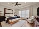 Spacious bedroom featuring tray ceilings, a decorative bench, and large windows with natural light at 1120 Hooper Pl, Durham, NC 27703