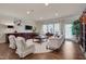Bright living room featuring a decorative fireplace, hardwood floors, large windows and elegant furniture at 1120 Hooper Pl, Durham, NC 27703