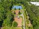 An aerial view capturing community tennis courts, a fenced dog park, and walking path amidst lush greenery at 1201 Somers Dr, Morrisville, NC 27560