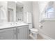 Neutral bathroom with a shower, toilet, marble countertop sink with faucet and window at 1201 Somers Dr, Morrisville, NC 27560