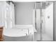 Close-up of a luxurious white soaking tub and glass-enclosed shower in the primary bathroom at 1201 Somers Dr, Morrisville, NC 27560