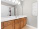 Bright bathroom featuring a wood vanity, white countertop, and large mirror above the sink at 1201 Somers Dr, Morrisville, NC 27560