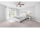 Bright bedroom with large window, ceiling fan, and neutral décor; modern and serene space at 1201 Somers Dr, Morrisville, NC 27560