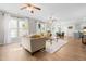 Bright, open-concept living area with natural light and wood floors, adjacent to the dining area and kitchen at 1201 Somers Dr, Morrisville, NC 27560