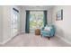 Sitting room with cozy chair, woven table, large window, and a door leading to the balcony at 1201 Somers Dr, Morrisville, NC 27560